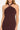 Woman wearing a burgundy halter neck dress on a white background